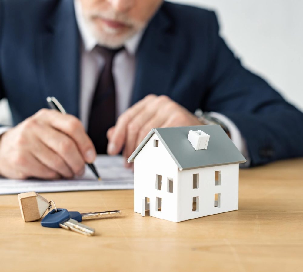 selective-focus-of-house-model-near-keys-and-house-dealer.jpg